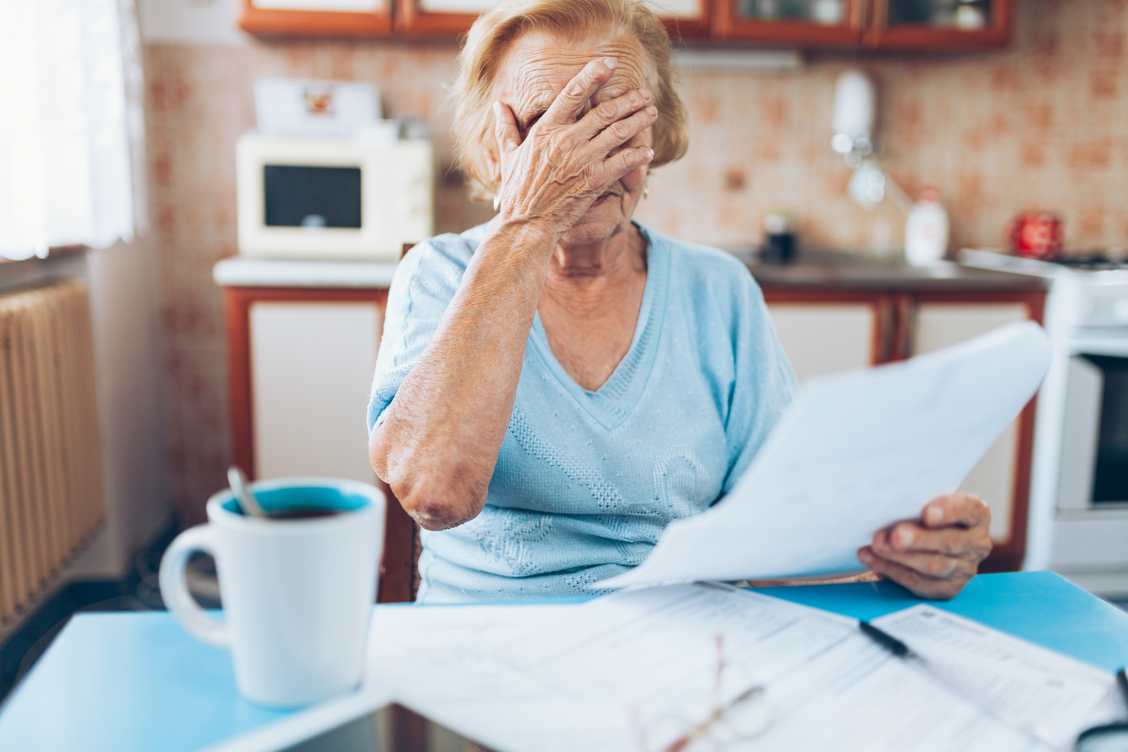 Elderly Woman Looking at Her Utility Bills
